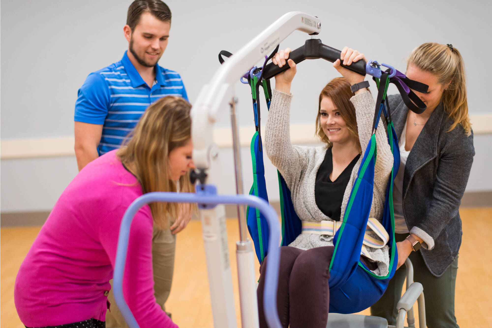 occupational therapy simulation of person using equipment assisted by students
